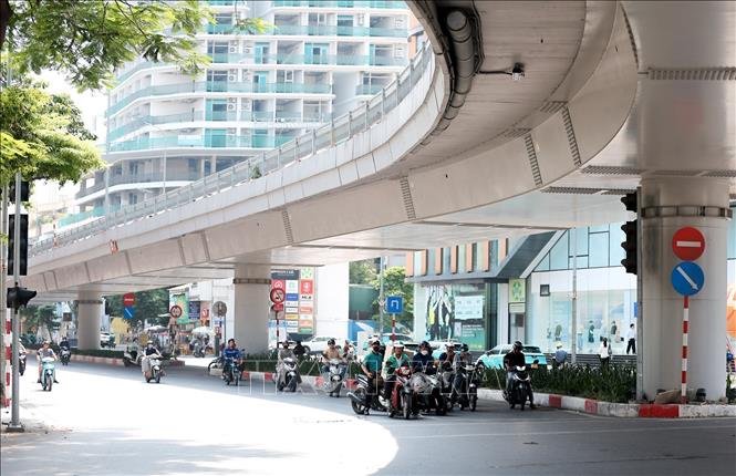 Nhiều phương tiện tham gia giao thông sử dụng bóng râm của cầu vượt để tránh nắng. Ảnh: Lê Đông - TTXVN