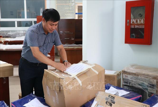 Ông Trần Văn Linh, chuyên viên Công nghệ thông tin, chuyển đổi số, Sở Giáo dục và Đào tạo Khánh Hòa sắp xếp lại tài liệu hồ sơ chuyển từ Ninh Thuận cũ về Sở Giáo dục và Đào tạo Khánh Hòa. Ảnh: Phan Sáu - TTXVN