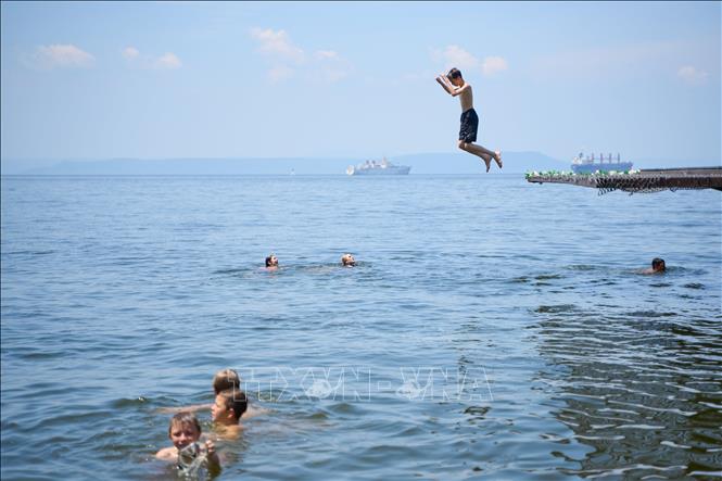 Người dân tắm biển tránh nóng tại Vladivostok, Nga. Ảnh: THX/TTXVN