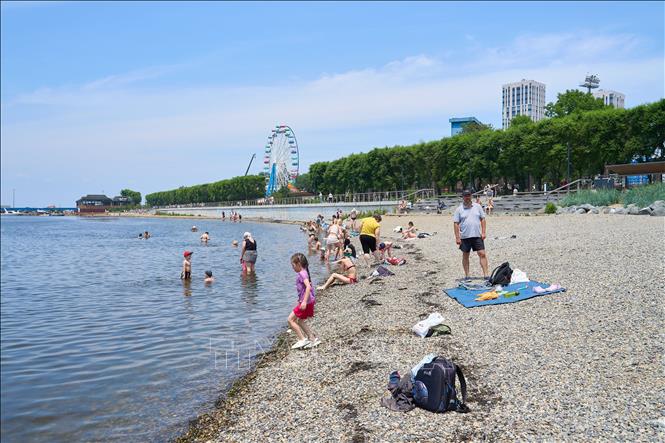 Người dân tắm biển tránh nóng tại Vladivostok, Nga. Ảnh: THX/TTXVN