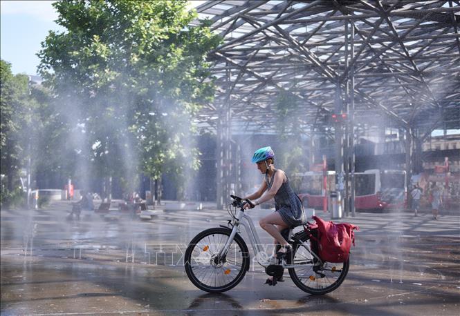 Người dân tránh nóng bên đài phun nước tại Vienna, Áo, ngày 3/7/2025. Ảnh: THX/TTXVN