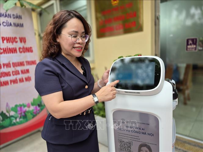 Bà Trịnh Ngọc Trâm, Phó Chủ tịch UBND phường Cửa Nam giới thiệu những tính năng ưu việt của Robot AI. Ảnh: Nguyễn Thắng - TTXVN 