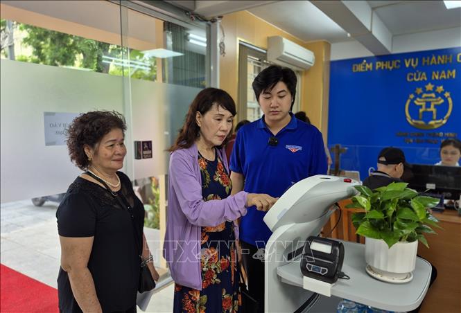 Người dân trải nghiệm Robot AI áp dụng công nghệ trí tuệ nhân tạo hỗ trợ thực hiện các thủ tục hành chính. Ảnh: Nguyễn Thắng - TTXVN 