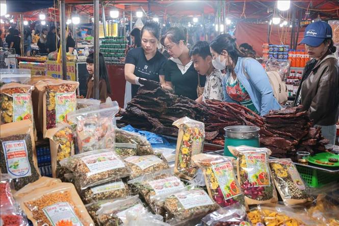 Du khách mua sắm các đặc sản địa phương tại chợ đêm Sapa. Ảnh: Hoàng Hiếu - TTXVN