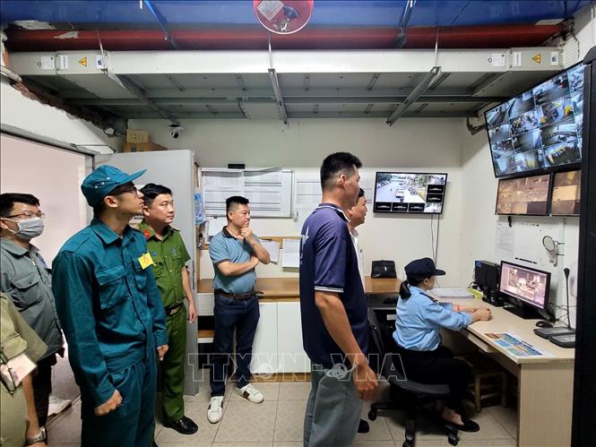 Cơ quan chức năng kiểm tra hệ thông camera giám sát an toàn phòng cháy, chữa cháy tại một chung cư. Ảnh: Linh Sơn-TTXVN