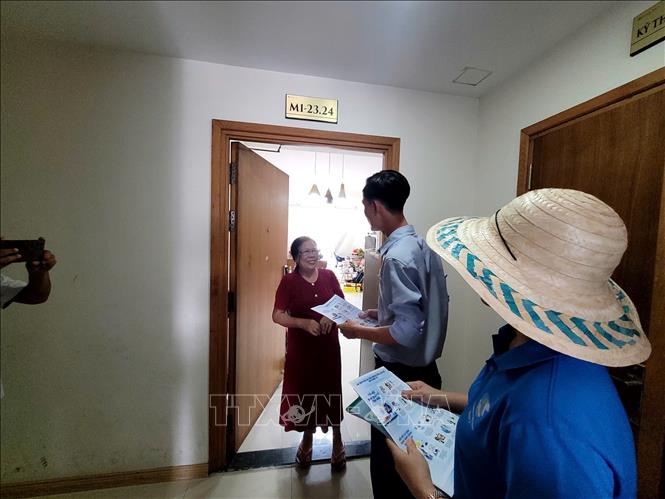 Ban quản lý chung cư Jamona City phát tờ rơi tuyên truyền phòng cháy, chữa cháy cho cư dân. Ảnh: Linh Sơn- TTXVN