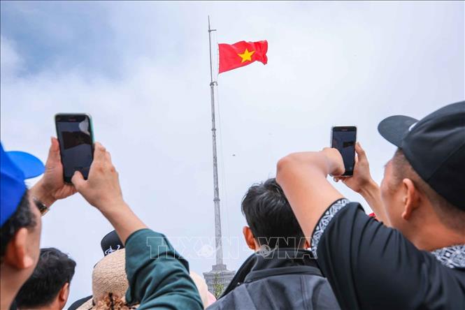 Người dân ghi lại khoảnh khắc lễ thượng cờ trên đỉnh Fansipan. Ảnh: Hoàng Hiếu - TTXVN