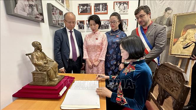 Phó Chủ tịch Quốc hội Nguyễn Thị Thanh viết lưu bút vào Sổ Vàng tại Không gian Hồ Chí Minh trong khuôn viên Bảo tàng Lịch sử Sống của thành phố Montreuil. Ảnh: Thu Hà - P/v TTXVN tại Pháp
