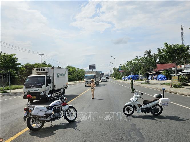 Lực lượng Cảnh sát giao thông hai tỉnh Vĩnh Long và Đồng Tháp phối hợp chặn dòng phương tiện để cầu Rạch Miễu trở thành đường 1 chiều trong khoảng 30 phút mỗi đợt để ưu tiên chiều còn lại. Ảnh: Chương Đài - TTXVN