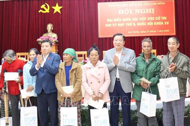 Đồng chí Phan Đình Trạc tặng quà cho các gia đình khó khăn, gia đình chính sách tại buổi tiếp xúc cử tri. Ảnh: Nguyễn Dũng – TTXVN 