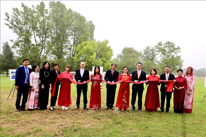 Đại sứ Vũ Quang Minh (thứ sáu từ trái) và ông Ngô Tuấn Phong, Phó Cục trưởng Cục Mỹ thuật, Nhiếp ảnh và Triển lãm (thứ tám từ trái) tham gia cắt băng khai trương Triển lãm ảnh về Việt Nam tại Vườn Thế giới. Ảnh: Phương Hoa - PV TTXVN tại Đức