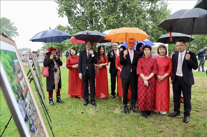 Ông Ngô Tuấn Phong, Phó Cục trưởng Cục Mỹ thuật, Nhiếp ảnh và Triển lãm (thứ hai từ trái) giới thiệu 50 bức ảnh về con người, văn hoá và phong cảnh thiên nhiên Việt Nam trưng bày tại Vườn Thế giới ở Berlin. Ảnh: Phương Hoa - PV TTXVN tại Đức 