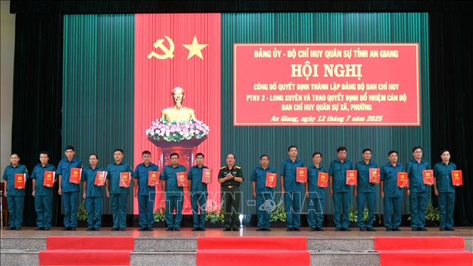 Đại tá Nguyễn Văn Ngành, Chỉ huy trưởng Bộ CHQS tỉnh An Giang trao quyết định trao quyết định của Chủ tịch UBND tỉnh điều động, bổ nhiệm cán bộ Ban Chỉ huy Quân sự các xã, phường. Ảnh: Văn Sĩ - TTXVN