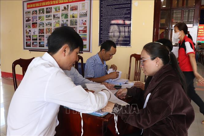 Người dân xã Tân Trụ, tỉnh Tây Ninh đến nhận thông tin về giải phóng mặt bằng tỉnh lộ 827E. Ảnh: Thanh Bình - TTXVN