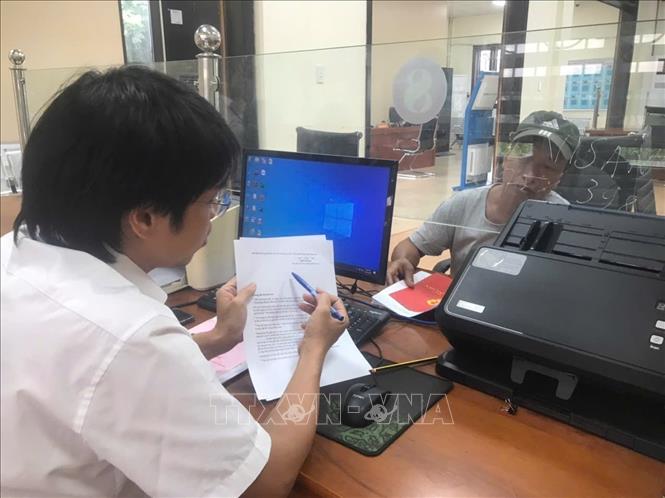 Cán bộ xã Cẩm Giàng - xã xa nhất vùng ven thành phố hướng dẫn người dân các thủ tục hành chính tại Trung tâm phục vụ hành chính công của xã. Ảnh: Tiến Vĩnh – TTXVN