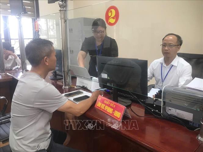 Cán bộ xã Cẩm Giàng - xã xa nhất vùng ven thành phố hướng dẫn người dân các thủ tục hành chính tại Trung tâm phục vụ hành chính công của xã. Ảnh: Tiến Vĩnh – TTXVN