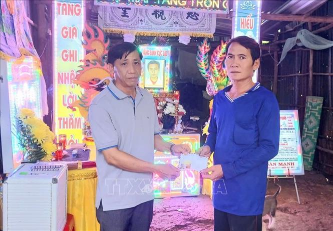 Ông Phạm Văn Tú, Phó Chủ tịch UBND xã Khánh Lâm (bên trái), trao hỗ trợ cho cha nạn nhân. Ảnh: TTXVN phát