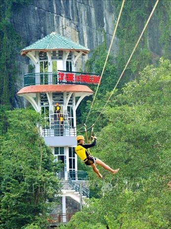Du khách tham gia loại hình đu dây tại tuyến du lịch sông Chày - hang Tối (Vườn Quốc gia Phong Nha - Kẻ Bàng). Ảnh: TTXVN
