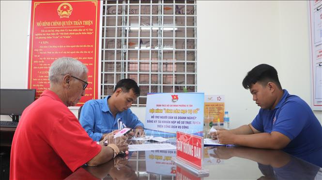 Lực lượng đoàn viên, thanh niên hỗ trợ người dân sử dụng ứng dụng VNeID trong giải quyết thủ tục hành chính. Ảnh: Hồng Thái - TTXVN