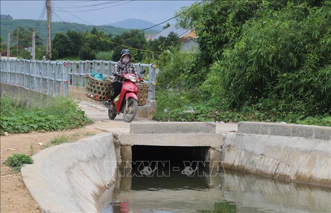 Người điều khiển phương tiện xe máy phải cẩn thận xử lý để không bị lao xuống máng nước khi vừa ra khỏi cầu máng. Ảnh: Xuân Tiến - TTXVN 
