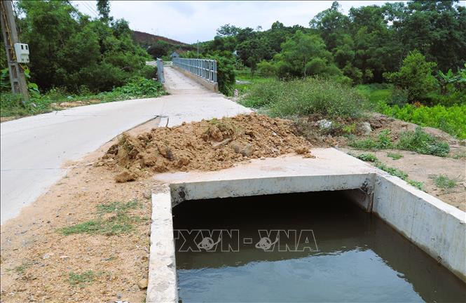 Để tránh người điều khiển phương tiện lao xuống máng nước, người dân đã phải đắp đất thành ụ ở phía đầu cầu máng. Ảnh: Xuân Tiến - TTXVN 