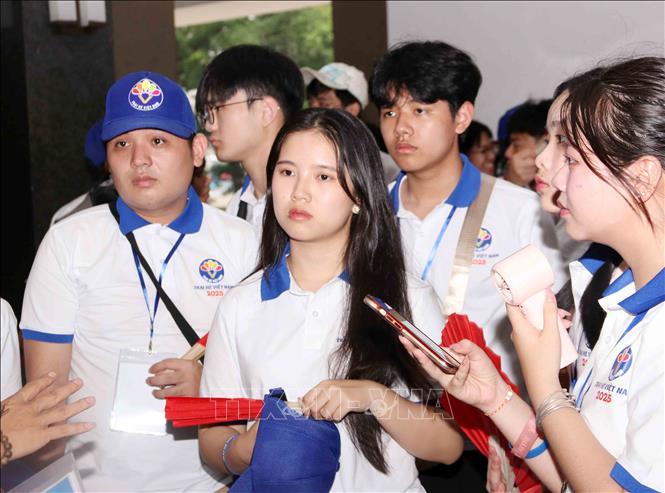 Bạn Vilatda Moungkhousin (Việt kiều Lào) cùng các bạn trại sinh nghe giới thiệu về Dinh Độc Lập trong khu di tích Hội trường Thống Nhất. Ảnh: Xuân Khu-TTXVN