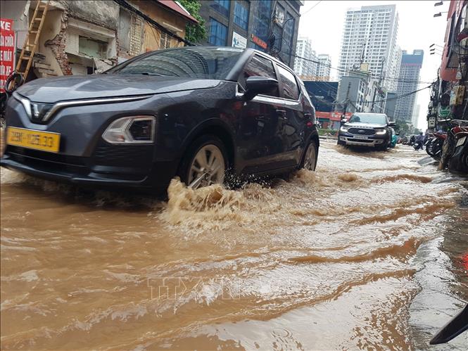 Phố Nguyễn Tuân ngập cục bộ khiến các phương tiện tham gia giao thông gặp khó khăn. Ảnh: Tuấn Anh - TTXVN
