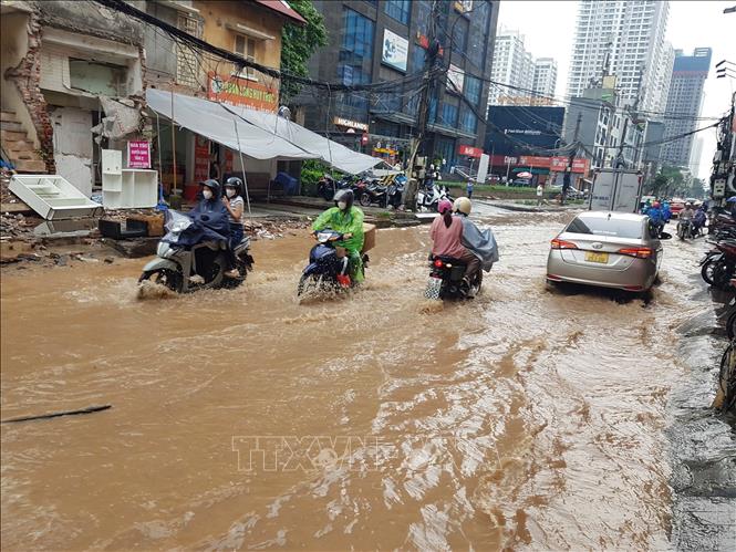 Phố Nguyễn Tuân ngập cục bộ khiến các phương tiện tham gia giao thông gặp khó khăn. Ảnh: Tuấn Anh - TTXVN
