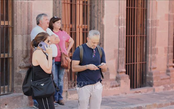 Du khách sử dụng dịch vụ di động để liên lạc tại thành phố du lịch San Miguel de Allende, bang miền Trung Guanajuato, Mexico. Ảnh: Phi Hùng - PV TTXVN tại Mexico