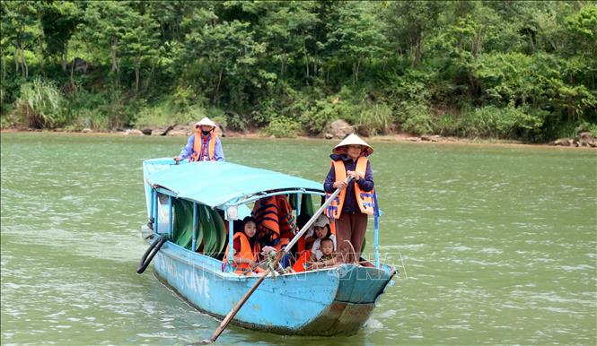 Thông qua hoạt động vận tải du lịch chở khách trên sông Son tham quan động Phong Nha, người dân tích cực tuyên truyền, giới thiệu hình ảnh và giá trị của Di sản thiên nhiên thế giới Vườn Quốc gia Phong Nha - Kẻ Bàng. Ảnh: Tá Chuyên - TTXVN