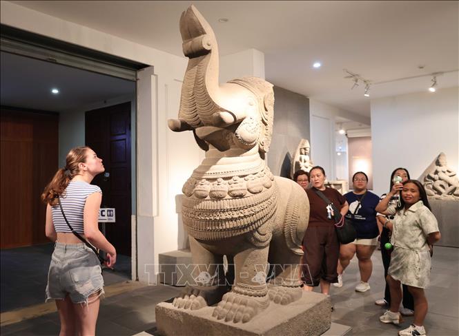 Foreign tourists explore artefacts on display at the Museum of Cham Sculpture. VNA Photo: Kha Phạm 