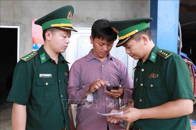 Cán bộ Đồn Biên phòng xuống bản, vào từng hộ dân để tuyên truyền về hòm thư diện tử ẩn danh tố giác tội phạm. Ảnh: Quý Trung - TTXVN