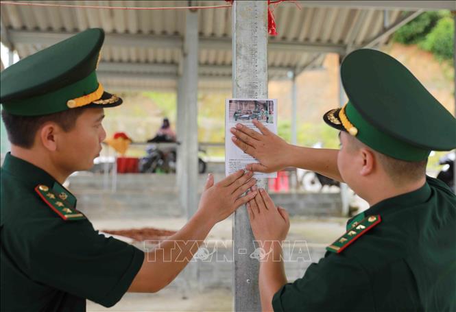 Dán mã QR tại chợ của xã Sin Suối Hồ để người dân dễ tiếp cận nhăm tố giác tội phạm tới hòm thư của đơn vị. Ảnh: Quý Trung - TTXVN