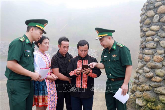 Cán bộ đội vận động quần chúng Đồn Biên phòng Sin Suối Hồ hướng dẫn người dân cách vào hòm thư để gửi thông tin tố giác tội phạm và ẩn danh. Ảnh: Quý Trung - TTXVN