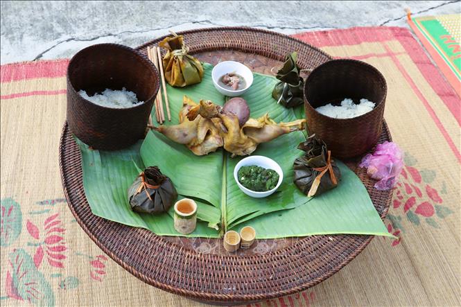 Các lễ vật trên mâm cúng gồm có gà luộc, xôi nếp nương, rượu đựng trong chén bằng ống nứa, các món moọc cá, moọc thịt, nộm rêu suối đựng trong bát sứ... Ảnh: Xuân Tiến - TTXVN 