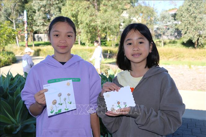 Children make mosaic from glass pebbles.VNA Photo: Thanh Tú