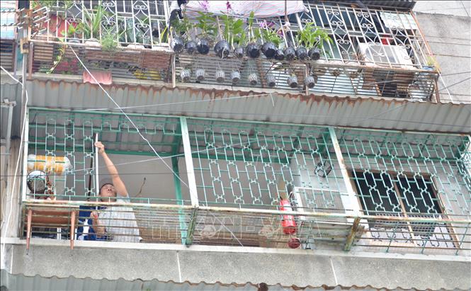 Một hộ dân cư xá Thanh Đa thuê thợ sắt tháo dỡ “chuồng cọp” ở ban công. Ảnh: Linh Sơn-TTXVN