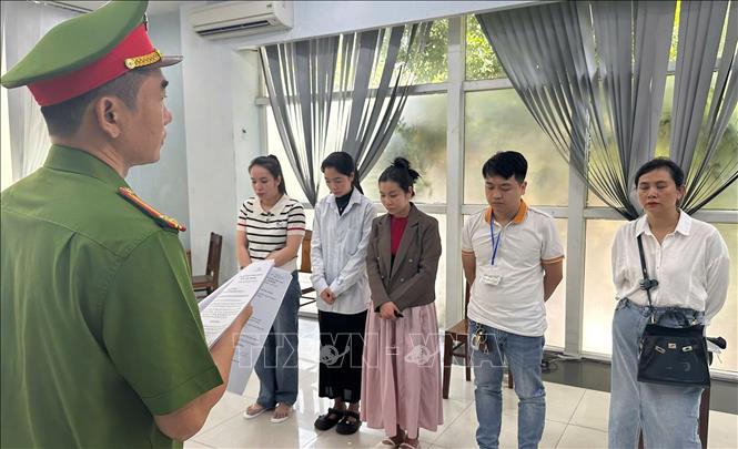 Lực lượng chức năng đọc lệnh Khởi tố tại việc Phòng khám Đa khoa Quốc tế Đà Nẵng. Ảnh: TTXVN phát  
