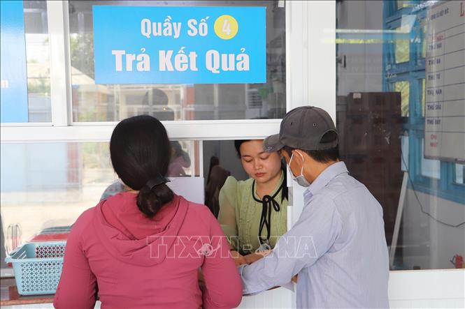 Người dân nhận kết quả giải quyết thủ tục hành chính. Ảnh: Minh Trí - TTXVN