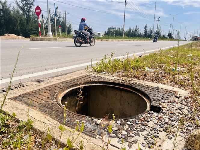 Kẻ gian đã lấy trộm gần 200 nắp hố ga trên tuyến đường 210 tỷ đồng nối Quốc lộ 1A đến Quảng trường biển Cam Hồng (Quảng Trị) để lại nhiều miệng hố nguy hiểm sát lề đường.. Ảnh: Nguyên Linh-TTXVN