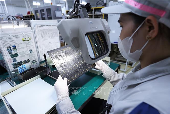 Kiểm tra sản phẩm bảng mạch in dùng cho các thiết bị điện tử bằng kính phóng đại qua màn hình tại nhà máy của Công ty TNHH Mektec Manufacturing Việt Nam (100% vốn Nhật Bản), khu công nghiệp Thăng Long II, phường Mỹ Hào, tỉnh Hưng Yên. Ảnh: Vũ Sinh - TTXVN