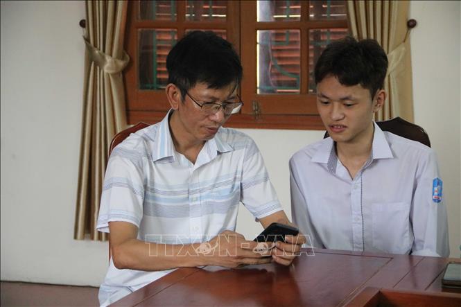 Em Trần Hữu Thịnh cùng thầy Hà Thanh Tuyển, Phó Hiệu trưởng trường THPT Hưng Nhân (tỉnh Hưng Yên). Ảnh: Thu Hoài - TTXVN 