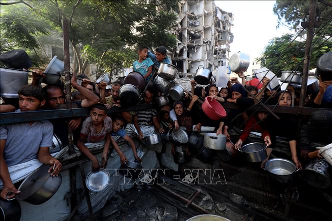 Người dân Palestine chờ được phát thực phẩm cứu trợ tại Gaza. Ảnh: THX/TTXVN
