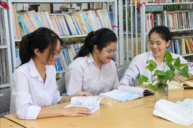 Em Nguyễn Thái An, thủ khoa tổ hợp A00 toàn quốc (giữa) trao đổi lại kiến thức cùng các bạn. Ảnh: Công Luật - TTXVN