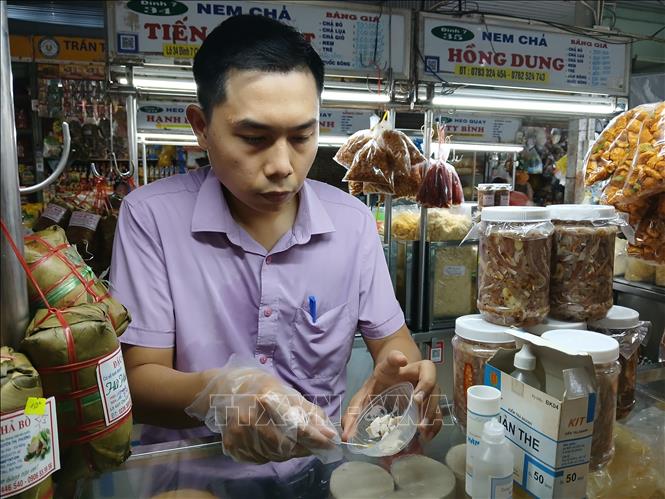 Lấy mẫu test nhanh chất phụ gia hàn the trong giò, chả tại chợ Cồn, thành phố Đà Nẵng. Ảnh: Mỹ Hà - TTXVN
