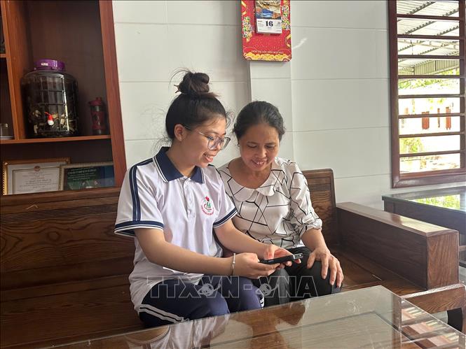 Em Nguyễn Đoàn Khánh Ly (trái), học sinh lớp 12 Hóa, trường THPT Chuyên Hà Tĩnh, xem điểm thi tốt nghiệp THPT năm 2025. Ảnh: TTXVN phát