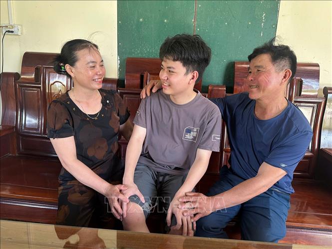 Em Trần Công Nguyên, học sinh lớp 12 Hóa, trường THPT Chuyên Hà Tĩnh, thủ khoa khối A00 chia sẻ niềm vui cùng bố mẹ sau khi biết điểm thi tốt nghiệp THPT năm 2025. Ảnh: TTXVN phát
