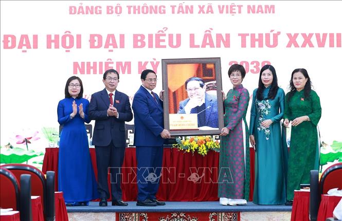 Tổng Giám đốc TTXVN Vũ Việt Trang và các đồng chí Phó Tổng Giám đốc tặng ảnh lưu niệm cho Thủ tướng Phạm Minh Chính. Ảnh: Dương Giang-TTXVN 