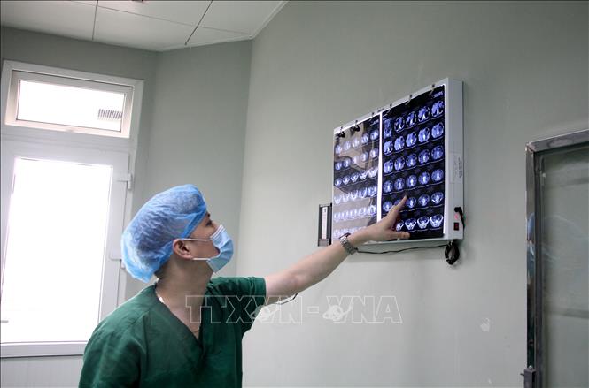 Tiến sĩ, bác sĩ Nguyễn Huy Toàn, Phó khoa Ngoại tổng hợp Bệnh viện Hữu nghị Đa khoa Nghệ An nghiên cứu hình ảnh X-quang trước khi tiến hành phẫu thuật. Ảnh: Văn Tý-TTXVN