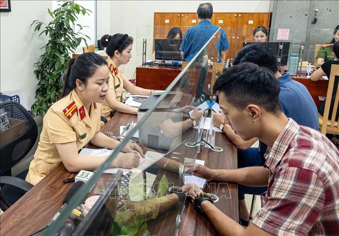 Người dân đến làm thủ tục đăng ký xe tại Công an phường Giảng Võ, thành phố Hà Nội. Ảnh: Phạm Kiên - TTXVN